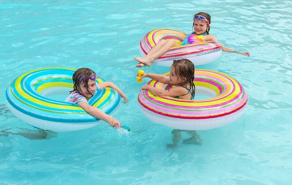 children floating on tubes in pool