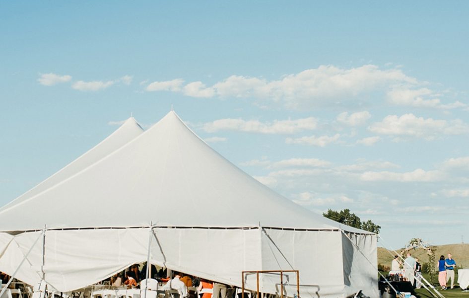 white tent set up for wedding on golf course