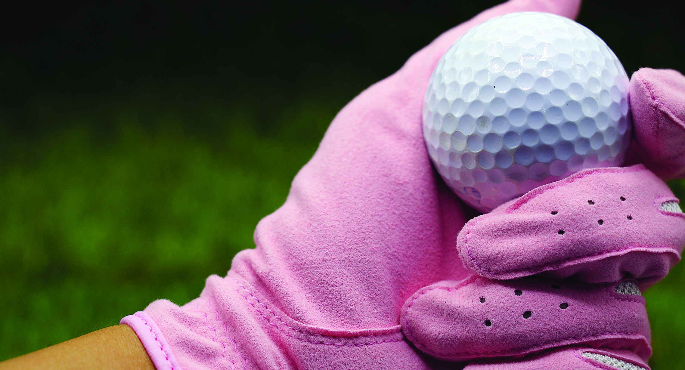 lady wearing pink golf gloves and holding golfball